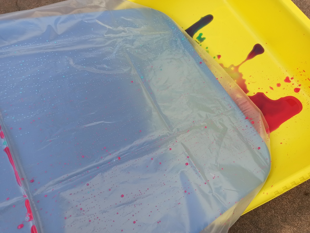 Gocce di acqua colorata che rotolano e finiscono nella vaschetta.